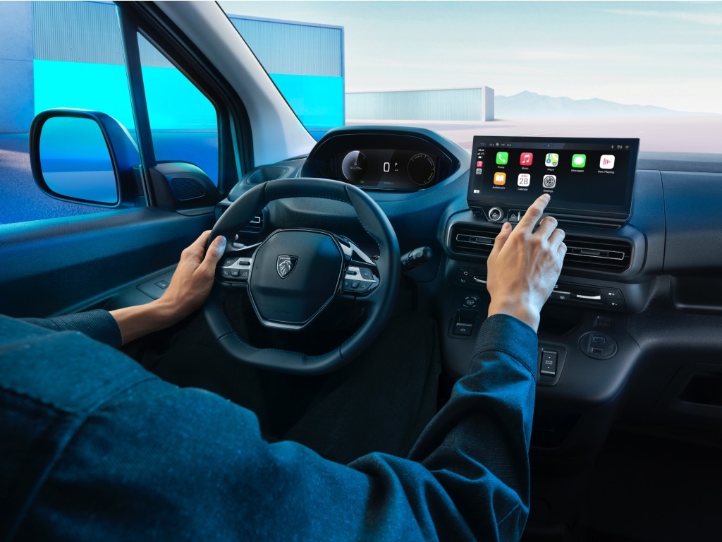 Mężczyzna w nowym PEUGEOT E‑PARTNER używa ekranu dotykowego