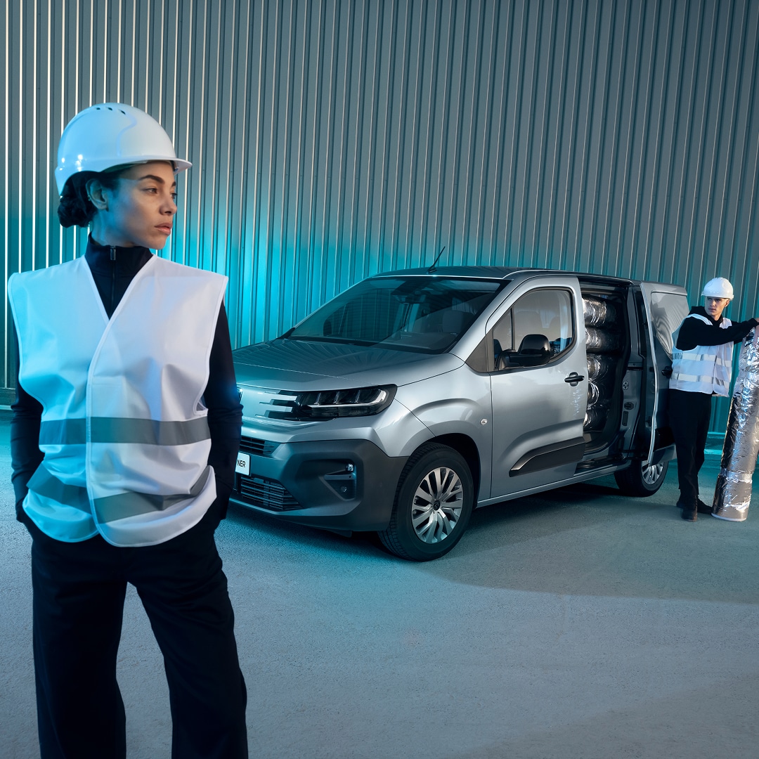 Woman standing in front of a PEUGEOT Partner