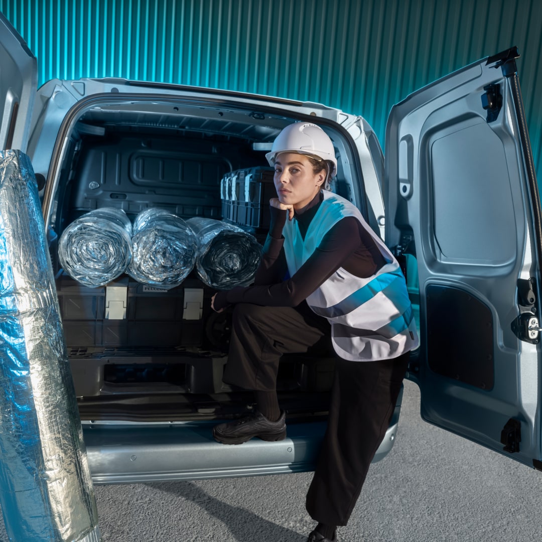 Woman loading cargo into the rear of a PEUGEOT Partner