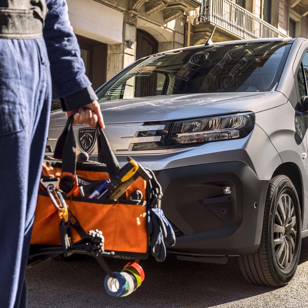 Woman standing in front of a PEUGEOT E-Partner